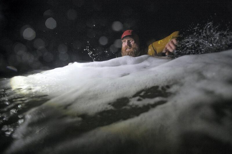 PORTRUSH, NORTHERN IRELAND - MARCH 01: Pro surfer Al Mennie swims through heavy surf at Downhill strand as he completes his 100KM night swim for charity on March 1, 2021 in Portrush, Northern Ireland. Pro big wave surfer Al Mennie has completed his Surf Swim Through The Darkness challenge of swimming 100KM in the dark throughout the winter months in the North Atlantic ocean to raise awareness of depression and funds for the Aware charity which promotes mental health awareness. (Photo by Charles McQuillan/Getty Images)