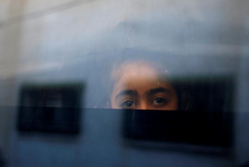 A Palestinian girl looks out a bus window as she waits to cross into Egypt through the Rafah border crossing. Mohammed Salem / Reuters