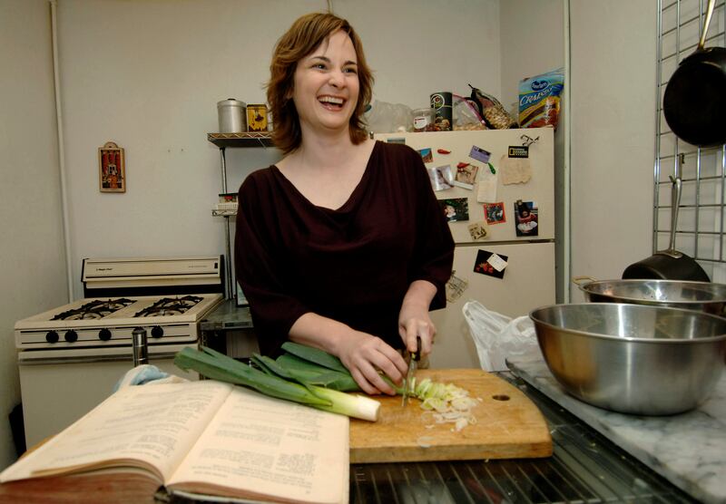 Julie Powell chops leeks to make potato leek soup, one of the first recipes in Julia Child's 'Mastering the Art of French Cooking', on the left, in her apartment in New York on September 30, 2005. AP Photo