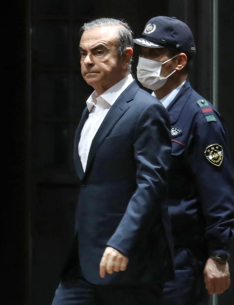 (FILES) This file photo taken on April 25, 2019 shows former Nissan chairman Carlos Ghosn (L) being escorted as he walks out of the Tokyo Detention House following his release on bail in Tokyo. Carlos Ghosn's escape from Japan is "unjustifiable" and he is thought to have left the country using "illegal methods", the Japanese justice minister said on January 5, 2020, in the first official public comments on the case. - Japan OUT
 / AFP / JIJI PRESS / STR
