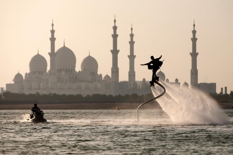 Abu Dhabi, United Arab Emirates, September 1, 2014:     A man flyboards in the Al Maqta Channel in front of the Sheikh Zayed Grand Mosque in Abu Dhabi on September 1, 2014. A Flyboard is a type of water jet-pack attached to a personal water craft which supplies propulsion to drive the device through air and water. Christopher Pike / The National

Reporter:  N/A
Section: News

Possible focal point