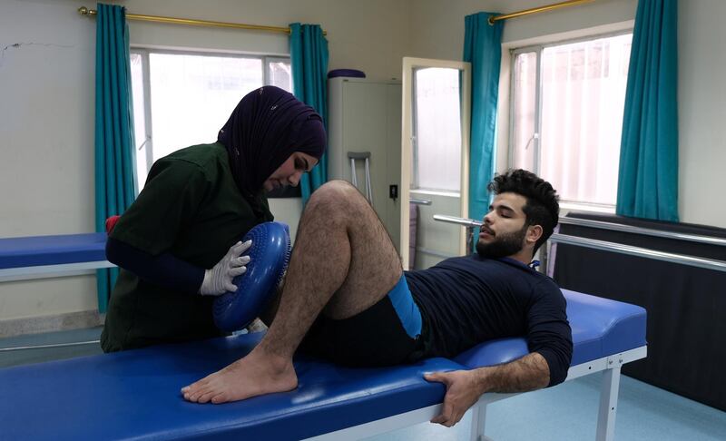 Physiotherapist Ashar Hassan attempts to insensitive Seif Salman's stump, without these exercises, he may be unable to use a prosthetic leg. Ameer Hazim for The National