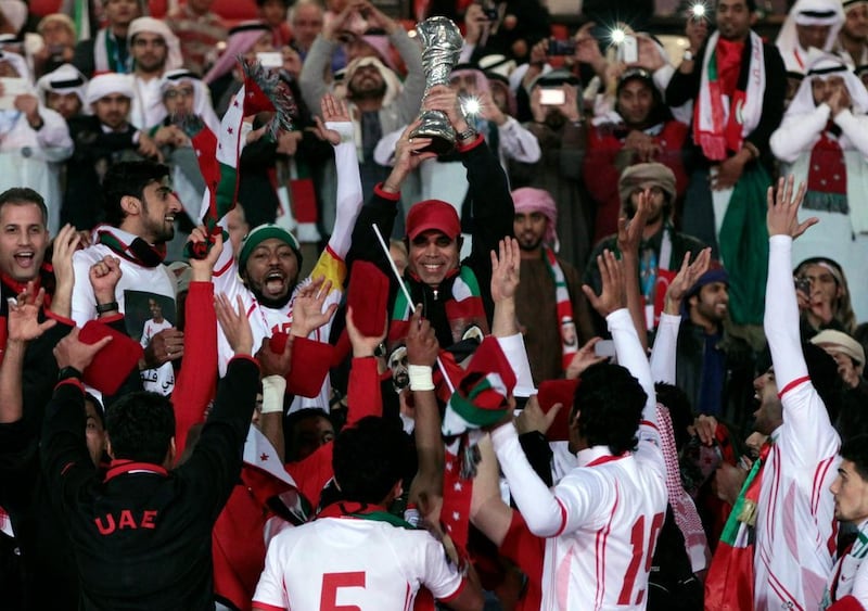 UAE coach Mahdi Ali holds aloft the Gulf Cup of Nations trophy after thee Emirates beat Iraq 2-1 in the final. AP Photo