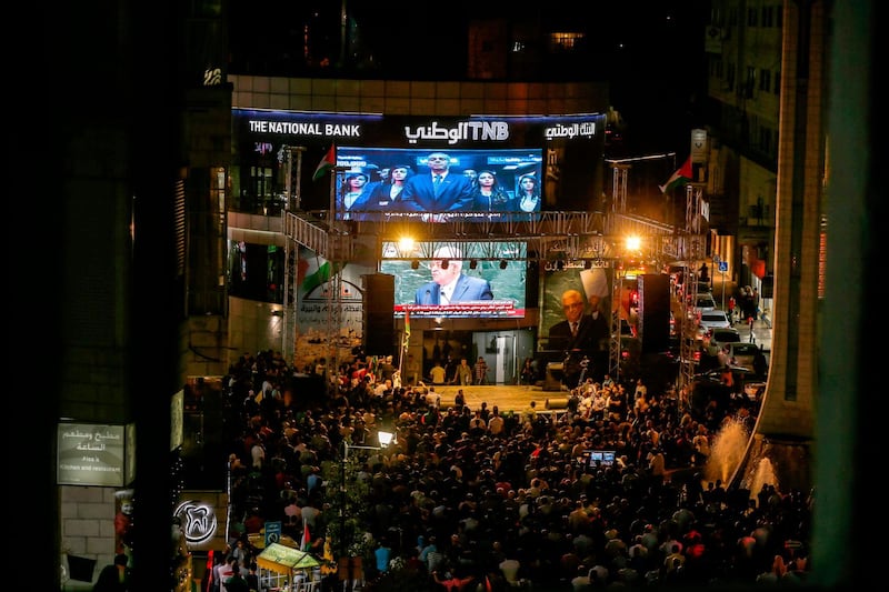 Palestinians watch Palestinian president Mahmoud Abbas on a large screen in the West Bank city of Ramallah. AFP