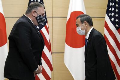 Michael Pompeo, U.S. Secretary of State, left, greets with Yoshihide Suga, Japan's prime minister, prior to a meeting at the prime minister's office in Tokyo, Japan, on Tuesday, Oct. 6, 2020. Pompeo will attend the Quadrilateral Security Dialogue (Quad) ministerial meeting later Tuesday in a bid to keep up the pressure on China amid the coronavirus crisis rocking Washington. Photographer: Eugene Hoshiko/AP Photo/Bloomberg