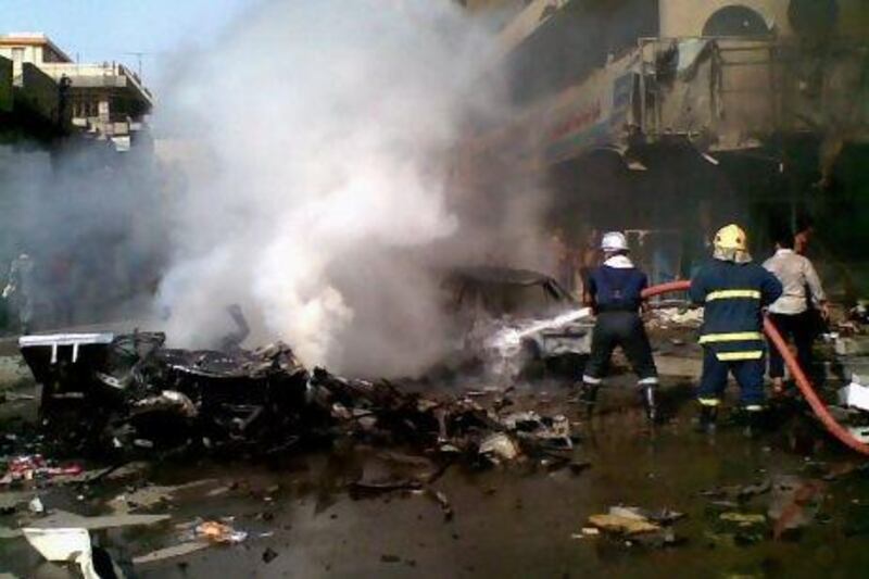 Iraqi firefighters extinguish a fire at the scene of a car bomb attack in Baghdad.
