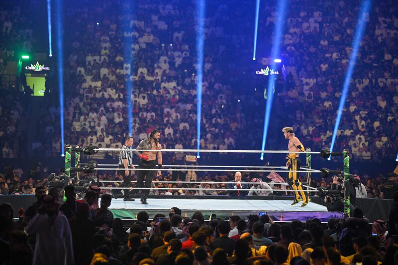 Roman Reigns and Logan Paul in the ring.