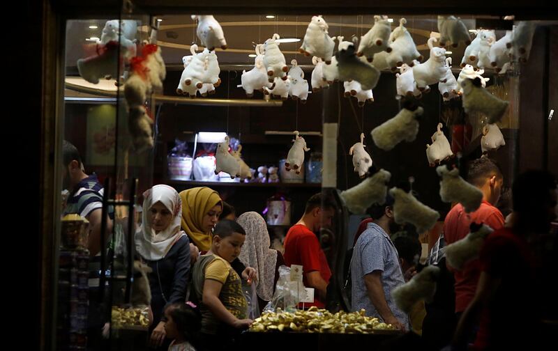 Palestinian families buy chocolate at a store in Gaza City decorated with sheep dolls, a symbol of the Muslim holiday of Eid Al Adha. AP Photo