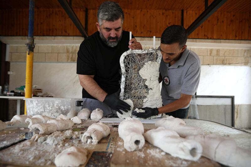 A worker helps Omar Sartawi, a Jordanian chef, as he recreates an ancient statue found in Jordan using a famous local product - Jameed (dried goat's milk used in the country's national dish), at his workshop in Amman, Jordan. REUTERS