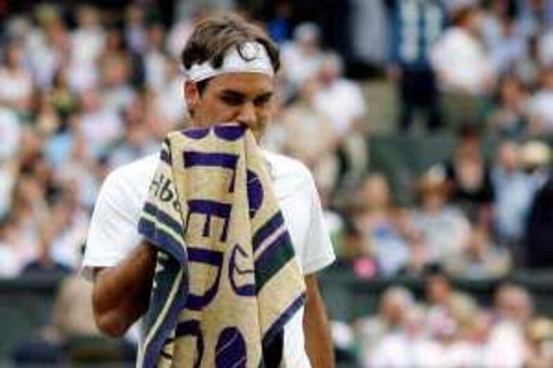 Switzerland's Roger Federer wipes his mouth during play against  Germany's Tommy Haas during their semi final match on Day 11 at the 2009 Wimbledon tennis championships at the All England Club on July 3, 2009. The event, the third Grand Slam tournament of 2009, runs from June 22  to  July  5, 2009. AFP PHOTO / GLYN KIRK