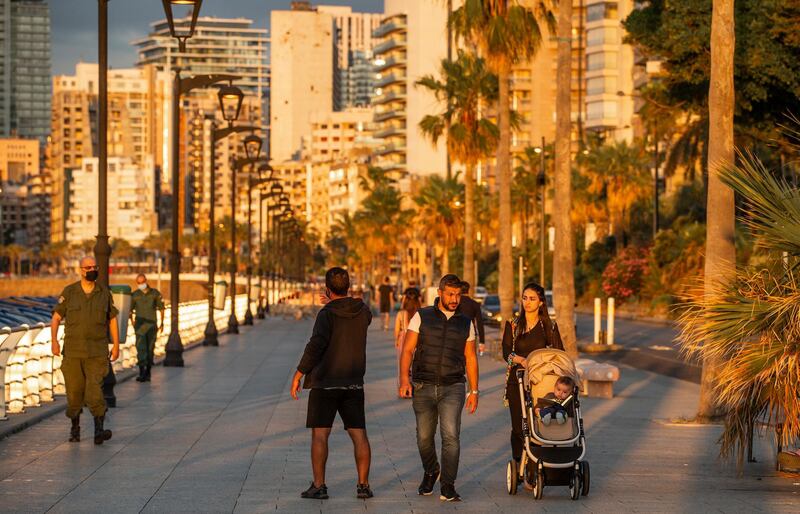 Policemen from the Beirut municipality warn citizens walking the promenade without wearing face masks along the Corniche Al Bahr just before the start of the nightly restrictions, in Beirut, Lebanon. EPA