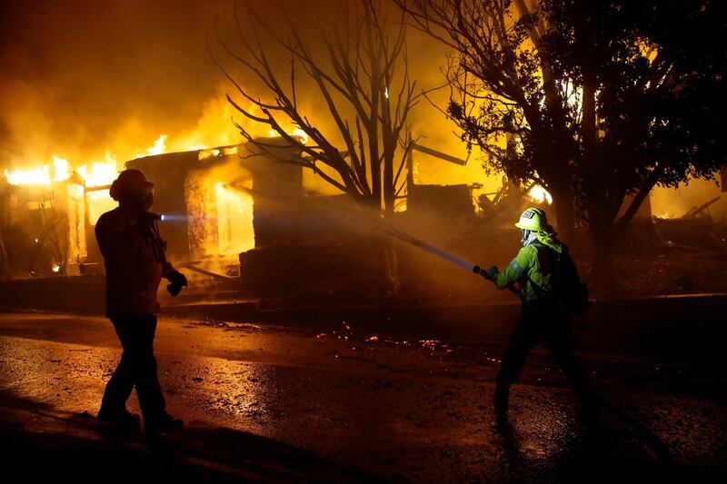 Firefighters hose down flames as a home burns in the Getty fire area along Tigertail Road, Monday, Oct. 28, 2019, in Los Angeles. (AP Photo/Marcio Jose Sanchez)