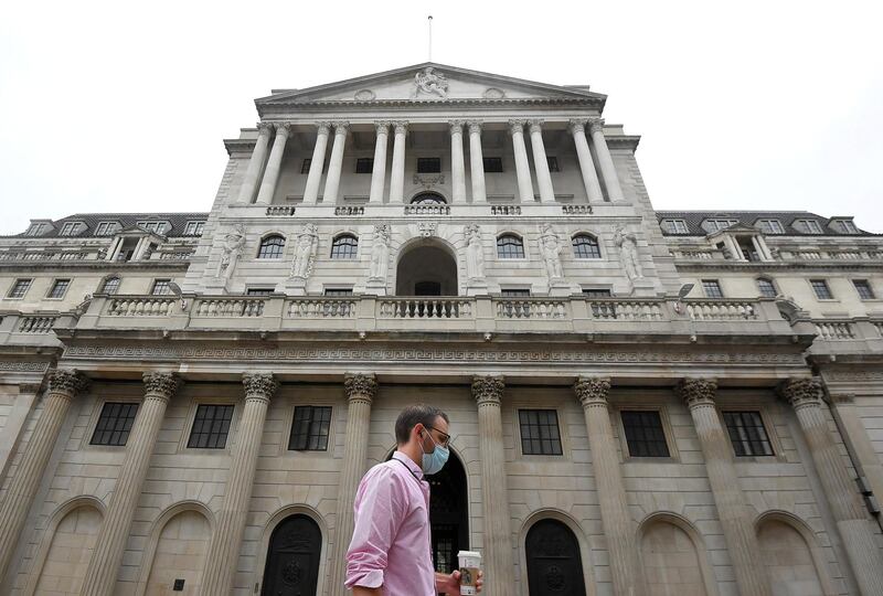 FILE PHOTO: A worker wearing a protective face mask walks past the Bank of England in the City of London, Britain, August 6, 2020. REUTERS/Toby Melville/File Photo