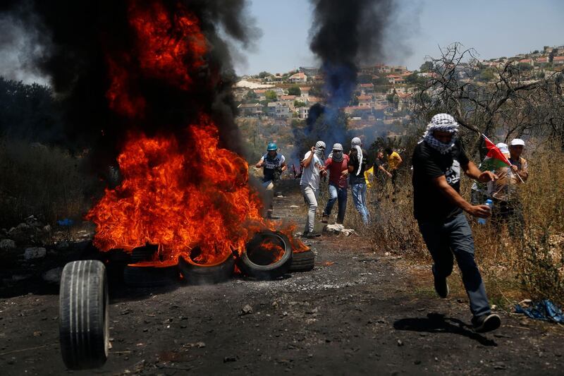 Palestinian demonstrators react to Israeli gunfire during a protest Israel's plan to annex parts Israel's plan to annex parts of the West Bank and Trump's mideast initiative, in the West Bank village of Kufr Qaddum near Nablus, Friday, July 3, 2020.(AP Photo/Majdi Mohammed)