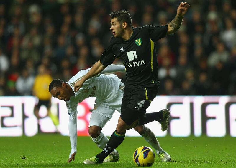 SWANSEA, WALES - DECEMBER 08:  Jonathan de Guzman of Swansea City battles for the ball with Bradley Johnson of Norwich City during the Barclays Premier League match between Swansea City and Norwich City at the Liberty Stadium on December 8, 2012 in Swansea, Wales.  (Photo by Paul Gilham/Getty Images)