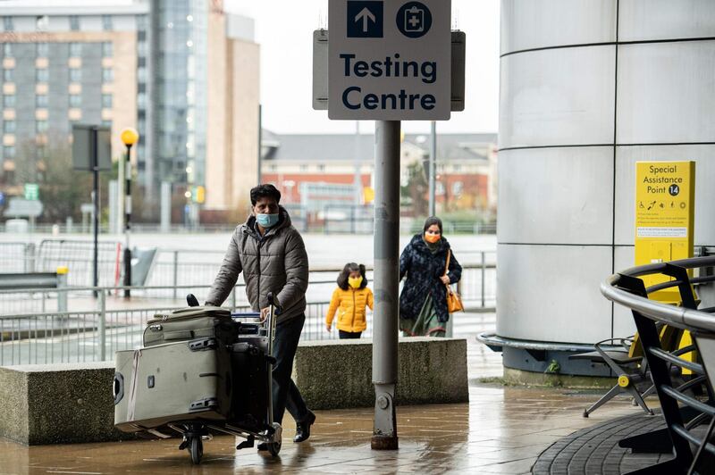 Travellers walk past signage directing passengers to the testing site. AFP