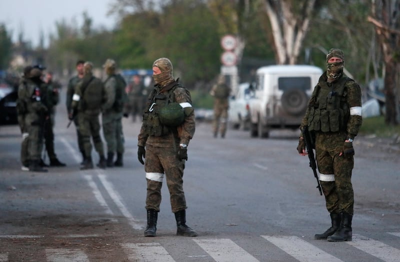 Pro-Russian troops stand guard on a road in Mariupol, Ukraine.  Reuters