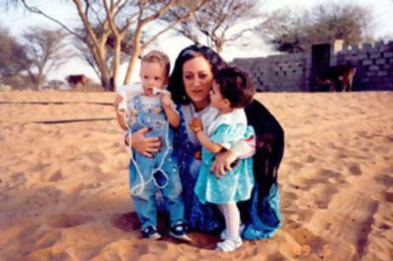 Inocenta Ewert holds her son Edward and Sheikh Sultan's daughter, Shamma, both two and milk siblings, in 1989.