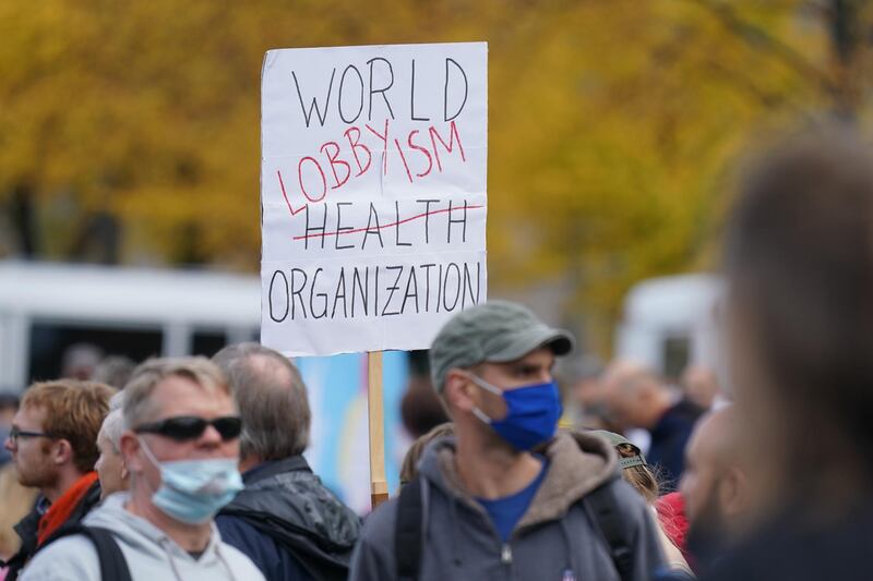 Protesters, including one holding a sign denigrating the World Health Organization, march to the Kosmos events venue where the World Health Summit was originally scheduled to take place in Berlin. Getty Images