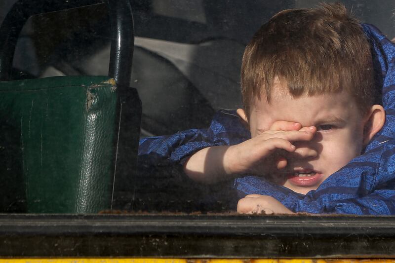 A boy looks through a bus window, waiting to be evacuated to Russia, in Donetsk, the territory controlled by pro-Russian militants, eastern Ukraine, Saturday, Feb.  19, 2022.  On Friday, separatist authorities in eastern Ukraine announced a mass evacuation of women, children and older adults to neighboring Russia.  The moves have have fueled Western fears that Moscow could use the latest violence in eastern Ukraine as a pretext for an invasion.  (AP Photo / Alexei Alexandrov)