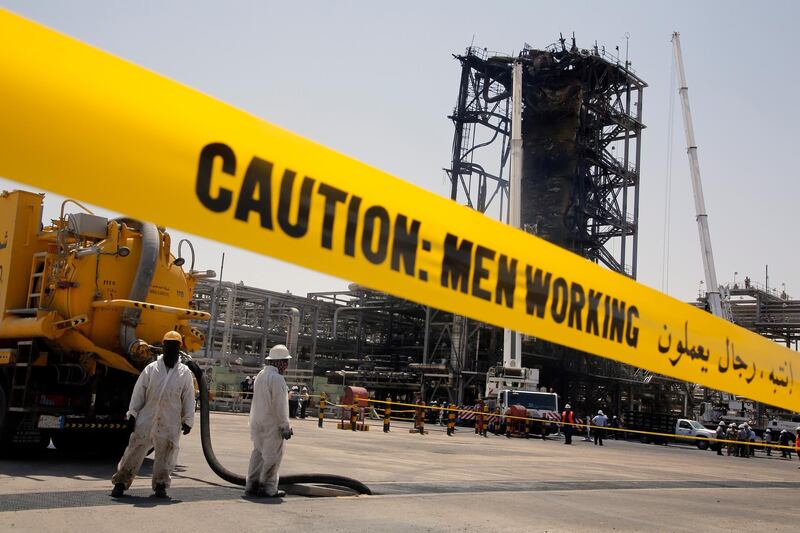 In this photo opportunity during a trip organized by Saudi information ministry, workers work in front of the recent attack Aramco's oil processing facility in Khurais, near Dammam in the Kingdom's Eastern Province, Friday, Sept. 20, 2019. (AP Photo/Amr Nabil)