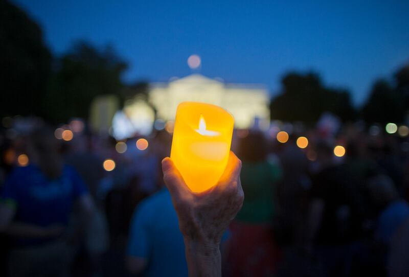 People hold up lights and candles during a national vigil 'to demand democracy' and to 'confront corruption', on Pennsylvania Avenue outside the White House in Washington. Michael Reynolds / EPA
