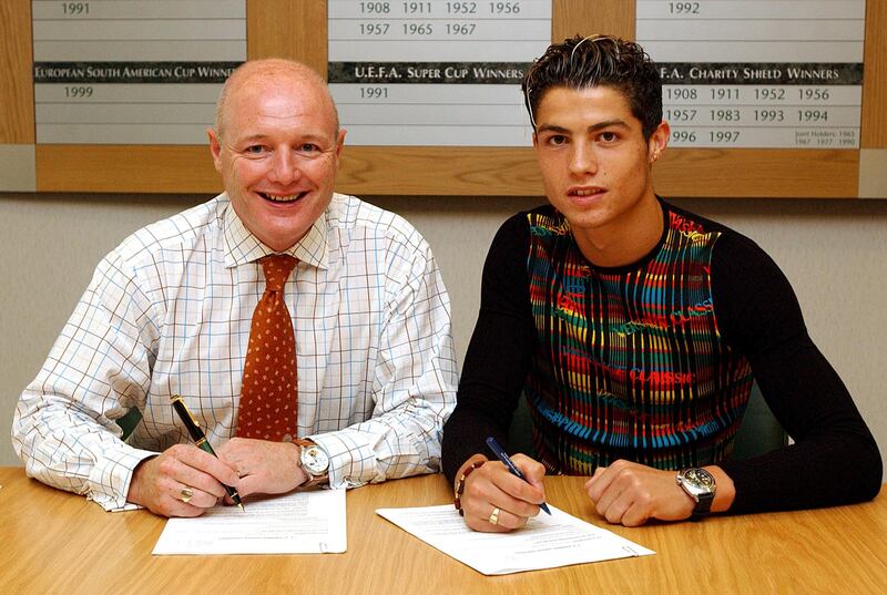 MANCHESTER, ENGLAND - AUGUST 12:   Chief Executive Peter Kenyon and Cristiano Ronaldo as the young Portugese player signs for Manchester United at Old Trafford on August 12, 2003 in Manchester, England.  (Photo by John Peters/Manchester United via Getty Images)