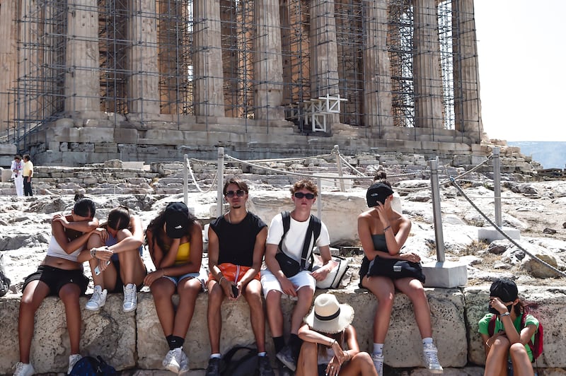 People struggle in the baking sun at the Acropolis in Athens