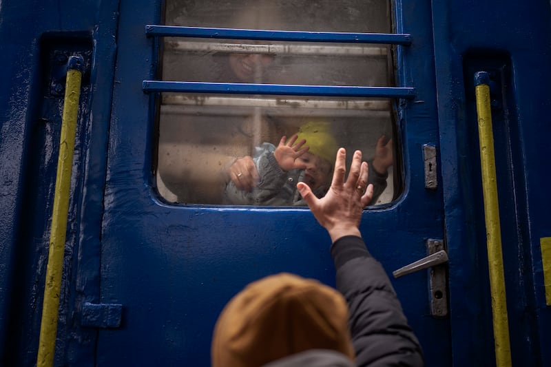 Stanislav says goodbye to his two-year-old son David and wife Anna after they boarded a train that will take them to Lviv, on March 3. AP