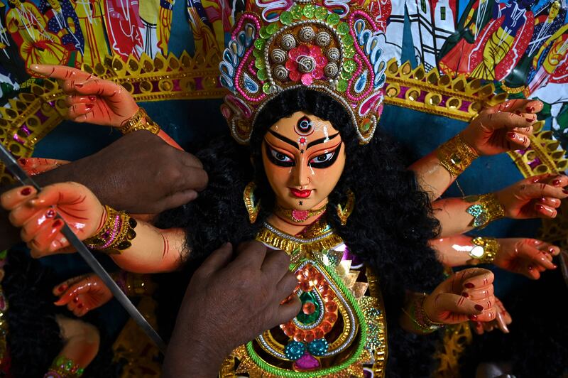 An artist gives the final touches to a sculpture depicting the Hindu goddess Durga at a workshop ahead of the upcoming Durga Puja festival, in Chennai on October 4, 2021. AFP