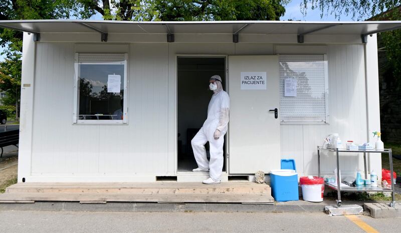 A medical worker wearing protective equipment waits at at a drive-through Covid-19 testing centre in Zagreb, Croatia. AFP