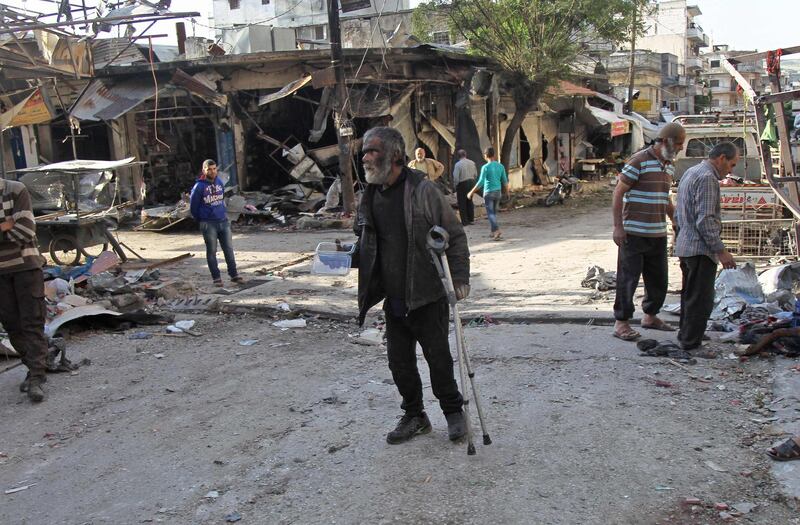 A Syrian whose shop was destroyed in an aerial bombardment walks around the area in Jisr al-Shughur, Idlib province.  AFP