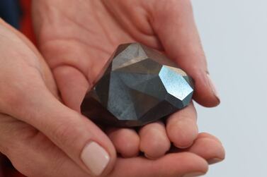A picture taken on January 17, 2022 shows "The Enigma", a 555. 55 carat black diamond, at Sotheby's in the Gulf emirate of Dubai.  (Photo by Giuseppe CACACE  /  AFP)
