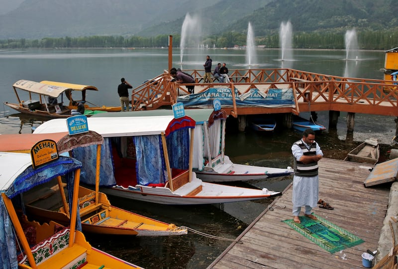 A man prays on the banks of Dal Lake in Srinagar. Reuters