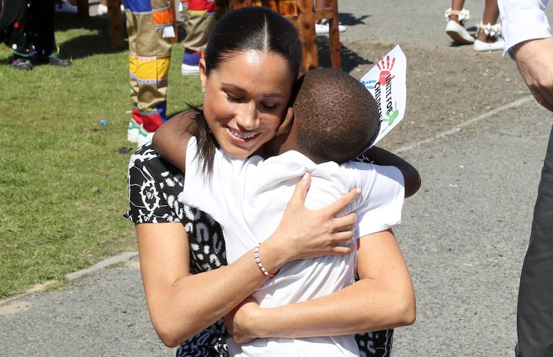 Meghan, Duchess of Sussex receives a hug from a young well-wisher as she visits a Justice Desk initiative in Nyanga township, with Prince Harry, Duke of Sussex, during their African tour in Cape Town, South Africa, on Monday September 23, 2019. Getty Images