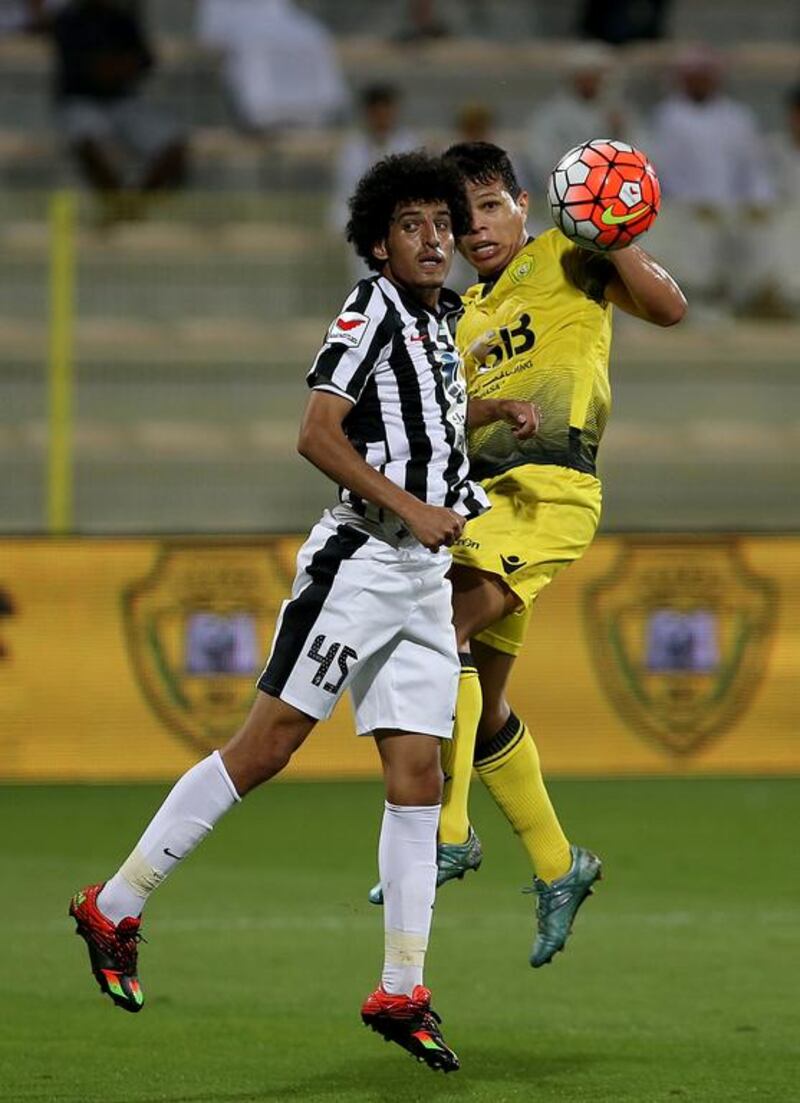 Al Wasl’s Fabio Lima, in yellow, and Al Jazira’s Saeed tussle for ball in the Arabian Gulf League on Friday night at Zabeel Stadium in Dubai. Ravindranath K / The National