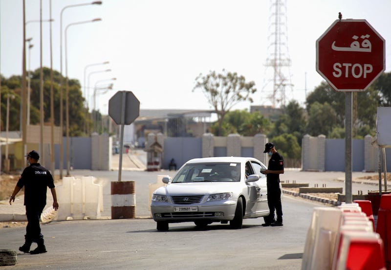 A Tunisian police officer checks a Libyan motorist at the border post in Ras Ajdir.  AFP