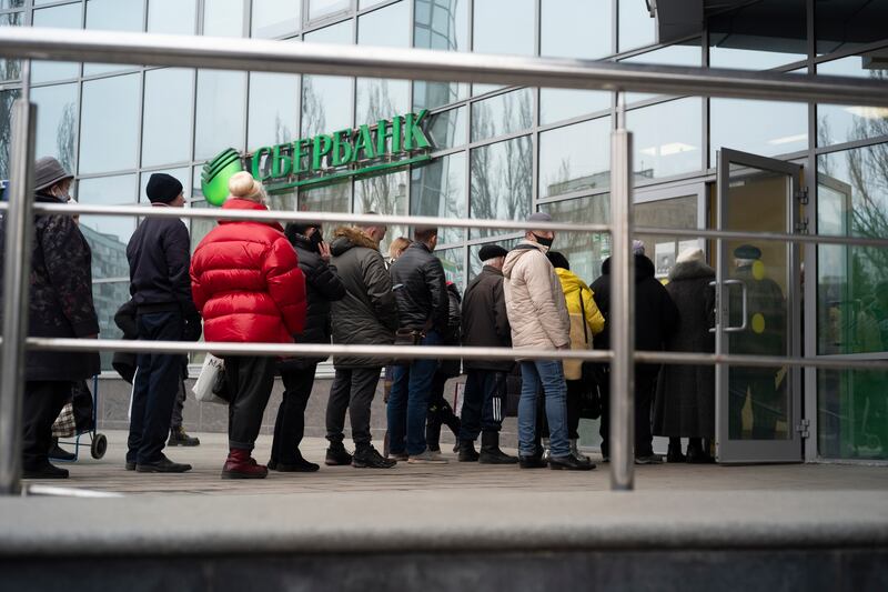 People stand in line to enter Sberbank in Moscow, Russia. Its UK investment arm is winding down operations. AP Photo