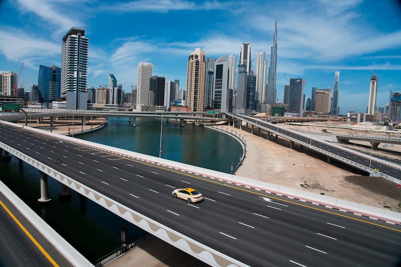 In this April 6, 2020, file photo, a lone taxi cab drives over a highway in front of the Dubai skyline. The United Arab Emirates announced on Saturday a major overhaul of the countryâ€™s Islamic personal laws, allowing unmarried couples to cohabitate, loosening alcohol restrictions and criminalizing so-called â€œhonor killings.â€ (AP Photo/Jon Gambrel, File)