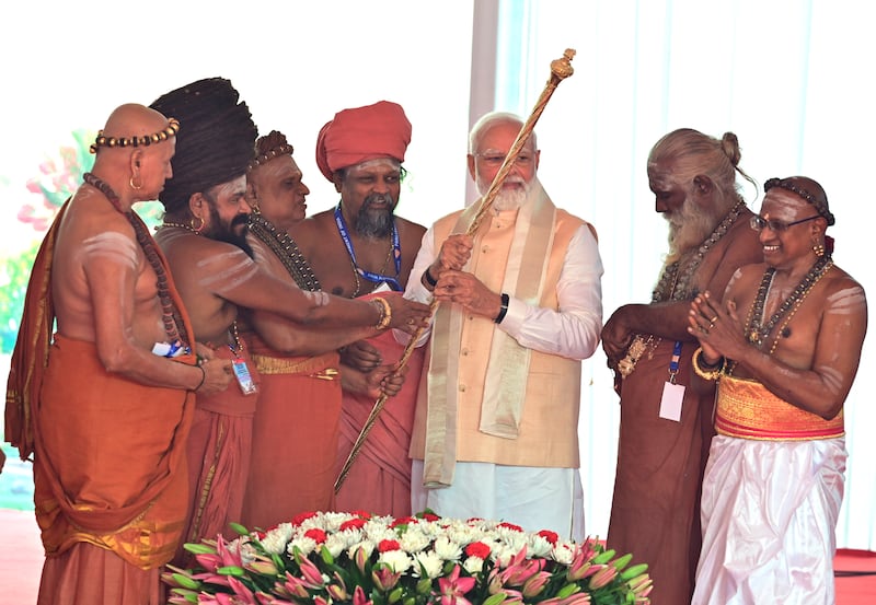 Hindu priests hand over a royal golden sceptre to Mr Modi, to be installed near the chair of the speaker. AP