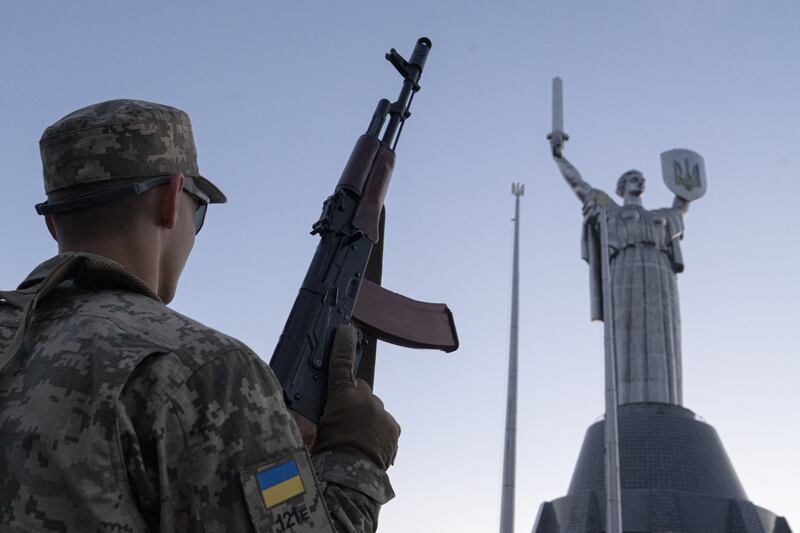 A Ukrainian cadet carries a machinegun below the Motherland Monument in Kyiv. Bloomberg