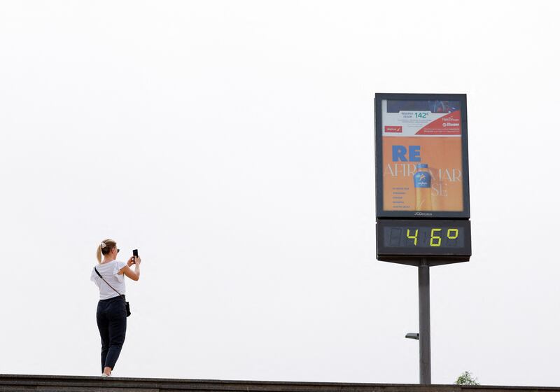A woman takes a picture of a temperature display in southern city Seville, as Spain experiences May temperatures 15°C above average. Reuters.