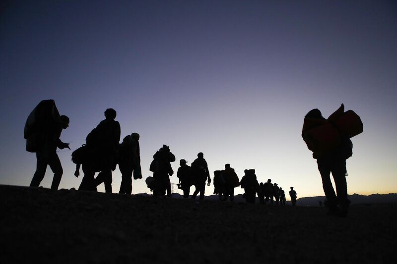 Walkers who are part of the 'migrant caravan' march at dusk on their way to Tijuana near Mexicali, Mexico. Getty