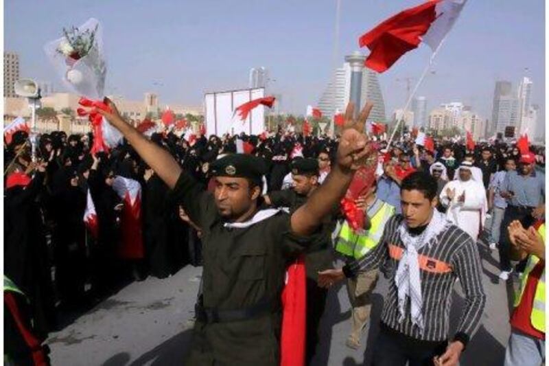 Police officers flowers as they walk with anti-government protesters in in Manama, Bahrain, yesterday.