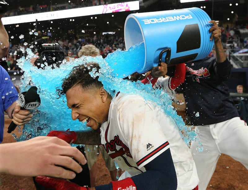 Atlanta Braves' Ozzie Albies and Julio Teheran douse Johan Camargo after he hit a walk-off home run to give the Braves a 7-6 win over the New York Mets in a baseball game in Atlanta. Curtis Compton / AP Photo