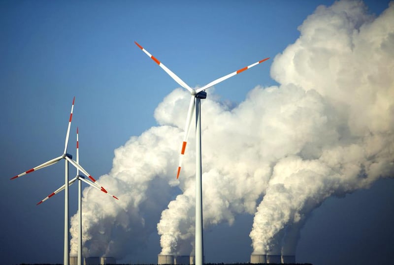 Steam billows from the cooling towers of Vattenfall’s Jaenschwalde brown coal power station behind wind turbines near Cottbus, eastern Germany. Pawel Kopczynski / Reuters
