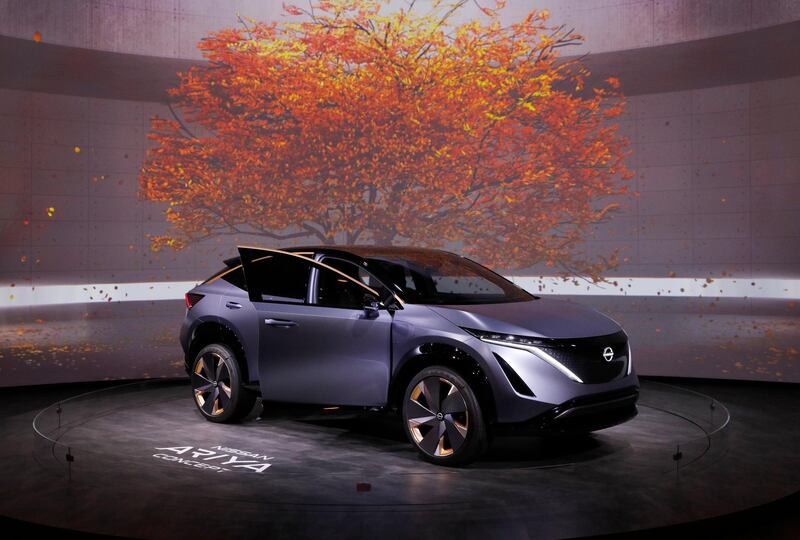 The Nissan Ariya sits beneath virtual leaves. AP