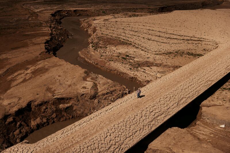 A man walks on the cracked ground of the Baells reservoir in Catalonia, Spain as supplies of drinking water plunge during an extreme drought. Reuters

