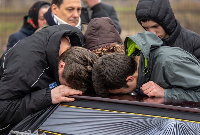 Family members grieve during the funeral of Ruslan Nechyporenko, 47, in Bucha. Getty Images