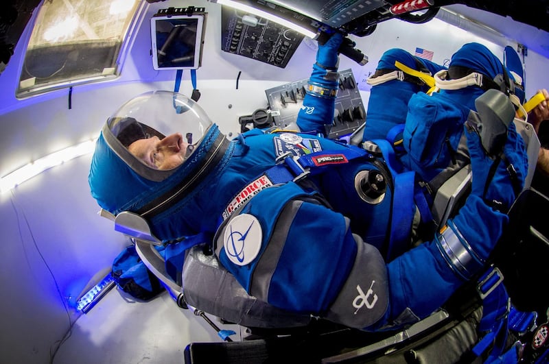 Chris Ferguson, Boeing director of crew and mission systems and a former astronaut, checks out the new, blue Starliner spacesuit in a mockup of the company's commercial crew spacecraft. Courtesy Boeing